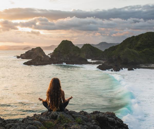 woman meditating on beach